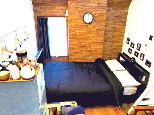 a bedroom with a bed and a clock on a wall at Shinagawa New Apt Easy access to both Haneda & Narita Airport in Tokyo