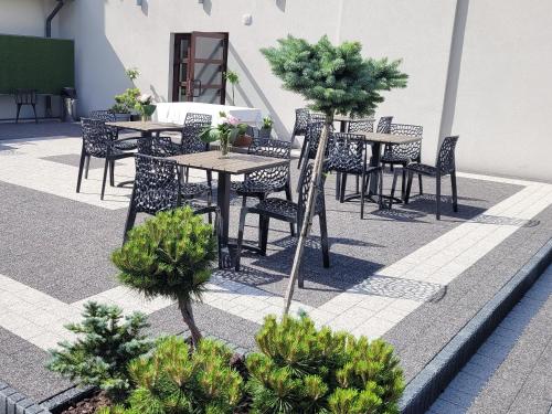 an outdoor patio with tables and chairs and trees at Hotel & Restauracja Wróblewscy in Karniewo