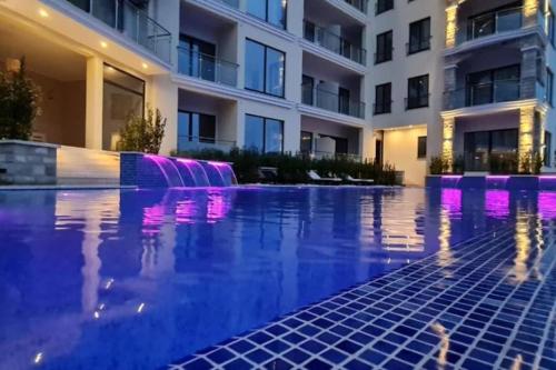 a swimming pool in front of a building at night at Modern Top Floor Sea View 3BR with Pools, Spa & Fitness in Becici