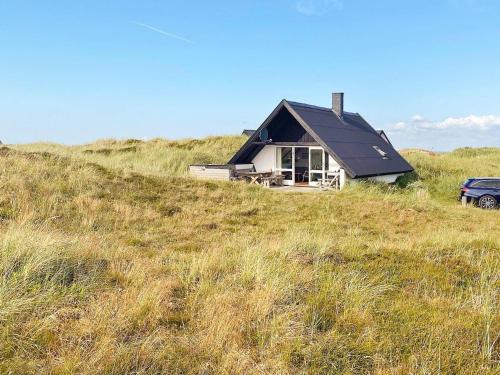 a house sitting on top of a grassy hill at 6 person holiday home in Ringk bing in Klegod