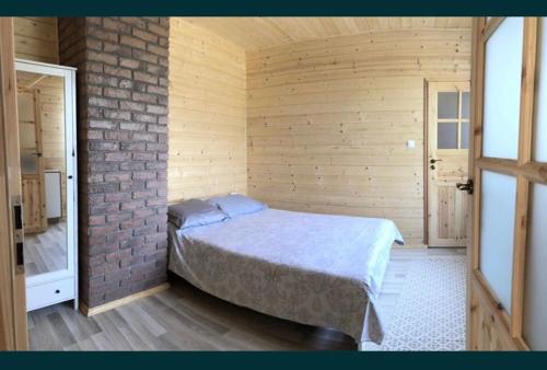 ein Schlafzimmer mit einem Bett in einer Ziegelwand in der Unterkunft Sielanka Mazurska Świętajno in Świętajno