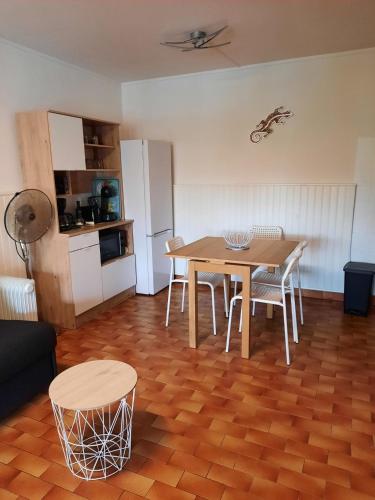 une cuisine et une salle à manger avec une table et des chaises dans l'établissement Appart en Duplex - 4/6 personnes, au Barcarès
