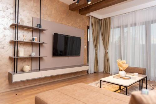 a living room with a television and a couch at Villa Selzo lux in Pale