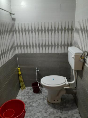 a bathroom with a toilet and a bucket at Soham resort 