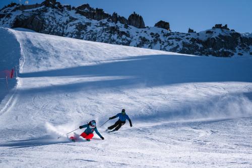 two people skiing down a snow covered slope at Affittacamere Sissi in Commezzadura