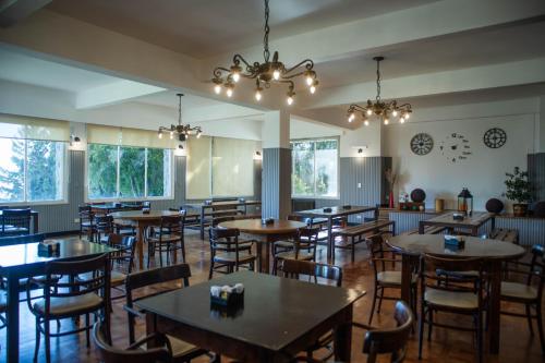 een eetkamer met tafels, stoelen en ramen bij Bella Vista in Bariloche
