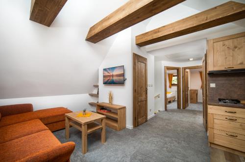 a living room with a couch and a table at Rezort pri Jazere Podbanské in Vysoké Tatry