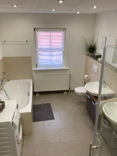 La salle de bains est pourvue d'une baignoire, de toilettes et d'un lavabo. dans l'établissement Basler Ferienwohnung, à Offenbourg