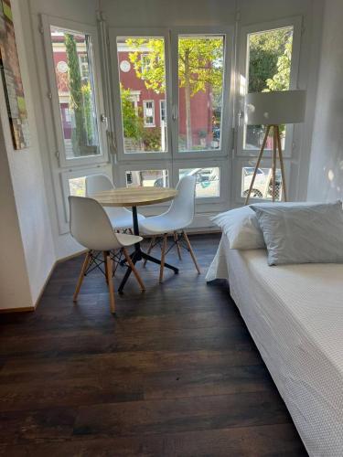 Schlafzimmer mit einem Bett, einem Tisch und Stühlen in der Unterkunft Basel-Stadt Gundeldingen Zimmer 401, WC in the hallway, outside the room in Basel