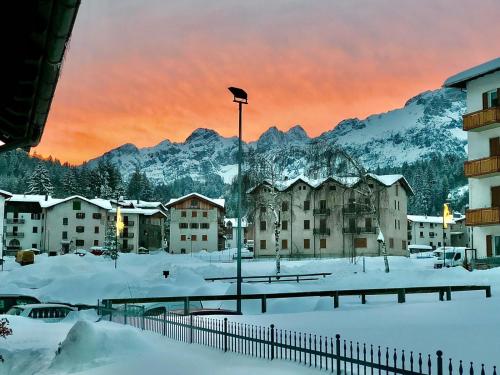 a snow covered city with buildings and a mountain at LE GEMME in Andalo