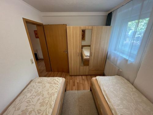 a small room with two beds and a window at Ruhige geräumige Wohnung in Pforzheim