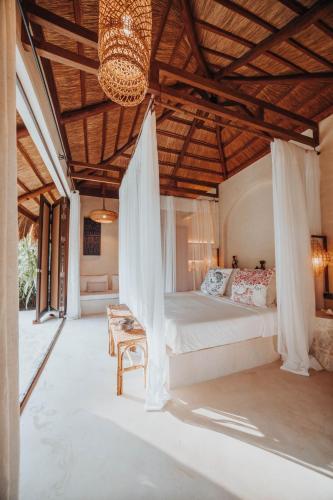 a bedroom with a bed and a chandelier at ALON Villas in El Nido