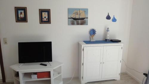 a living room with a tv and a white cabinet at FEWO-bis-2-Pers-inmitten-den-Yachthafens-Ueckermuende-Stettiner-Haff-Ostsee in Ueckermünde
