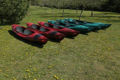 a group of kayaks lined up in a field at Auksinio elnio dvaras in Telšiai