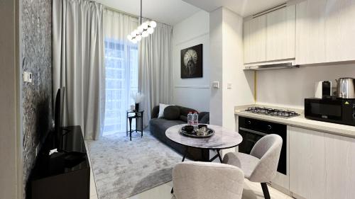 cocina y sala de estar con mesa y sofá en Business Bay - Near Metro Station - 1 Bedroom Apartments - Zada Tower - Keyrock HH en Dubái