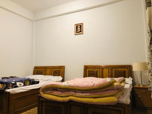- une chambre avec 2 lits jumeaux et une couverture dans l'établissement Sherpas Enclave, à Kalimpong