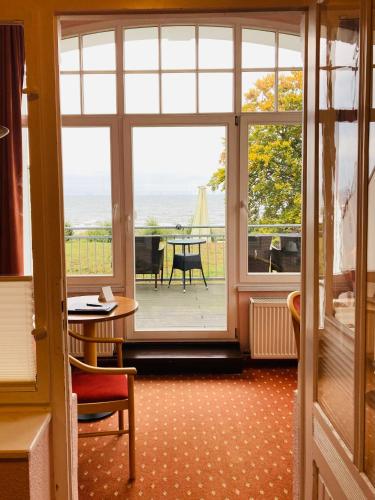a room with a large window with a view of the ocean at Hotel Germania in Bansin