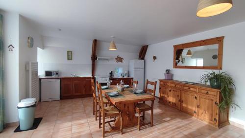 uma cozinha com uma mesa de madeira e cadeiras num quarto em Au Grand Bonheur - Gîte Padirac - Rocamadour em Miers