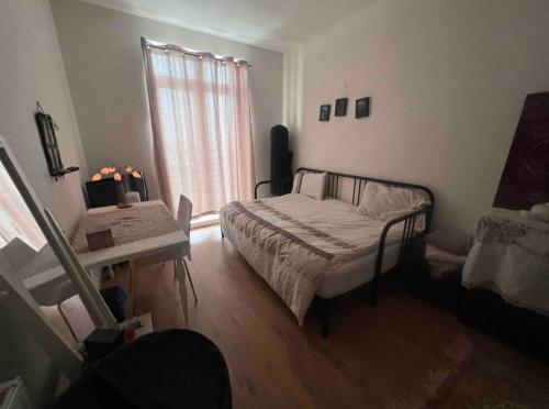 um quarto com uma cama, uma mesa e uma janela em Private Room BeachFront Apartment em Portsmouth