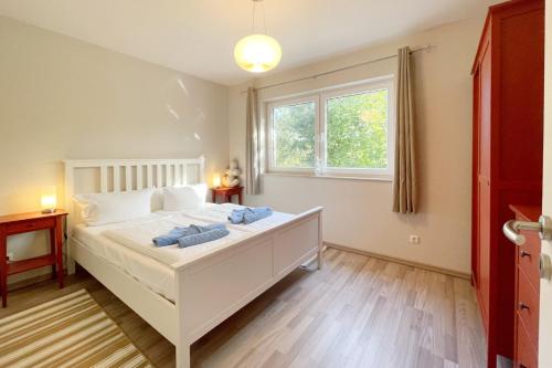 une chambre avec un lit blanc et une fenêtre dans l'établissement Strandstrasse 21 Ferienwohnung Domizil Auszeit, à Kolpinsee