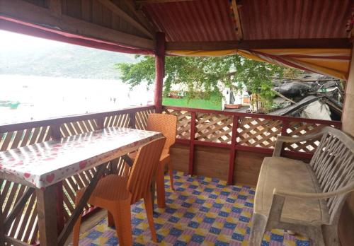 a table and chairs on a porch with a view of the water at Ramos Family Patungan Beach in Maragondon