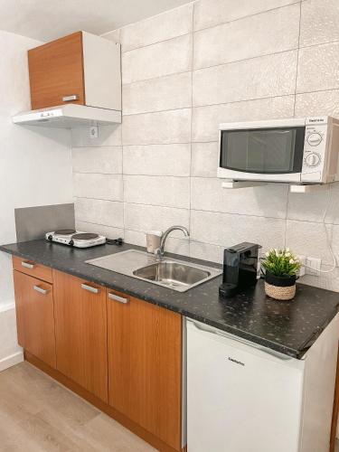 a kitchen with a sink and a microwave at Little Place Nazaré in Nazaré