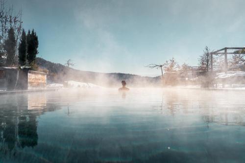 a man swimming in a body of water at Hotel Hirzer 2781 in Avelengo
