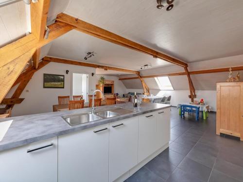 a kitchen with white cabinets and a dining room at In de Wollekjes in Merksplas