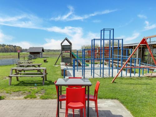 a playground with tables and chairs in a park at In de Wollekjes in Merksplas