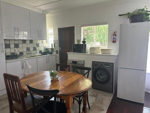 a kitchen with a wooden table and a refrigerator at INBLOEM in Bloemfontein