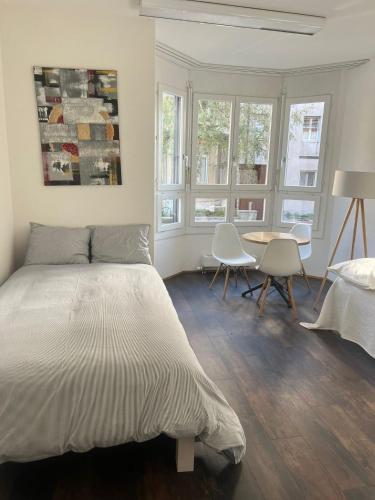 a bedroom with a bed and a table and chairs at Basel-Stadt Gundeldingen Zimmer 403, WC in the hallway, outside the room in Basel