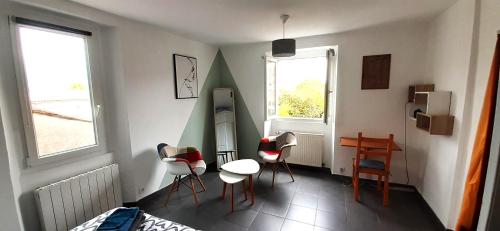 Cette chambre dispose de chaises, d'une table et d'un bureau. dans l'établissement Nos jours heureux, à Barjac