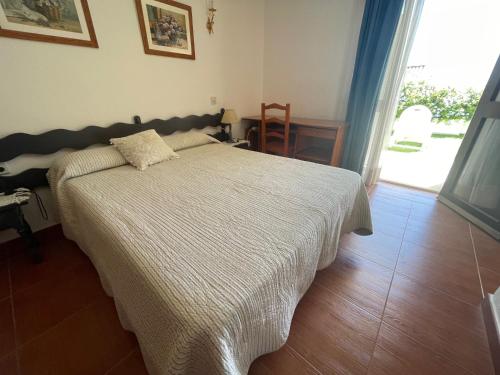 a bedroom with a bed with a white comforter at ESTEPONA BEACH SUITES 3. URB. ARENA BEACH 9 in Estepona