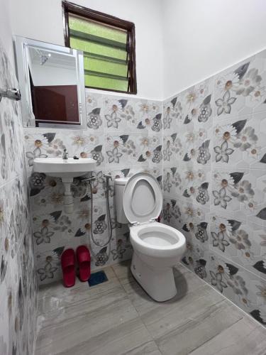 a bathroom with a toilet and a sink and a mirror at Studio Homestay in Sungai Buluh