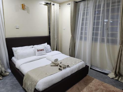 um quarto com uma cama grande com uma fita em Elysian Homes em Nakuru
