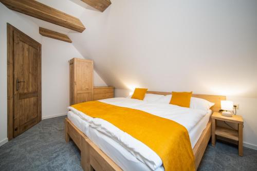 um quarto com uma cama grande e um cobertor amarelo em Rezort pri Jazere Podbanské em Podbanske