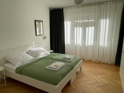 - une chambre avec un lit et 2 serviettes dans l'établissement SKAU Dunajska Family Two Bedroom Apartment Old Town, à Bratislava