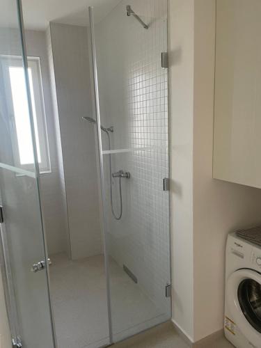 La salle de bains est pourvue d'une douche avec une porte en verre. dans l'établissement SKAU Dunajska Family Two Bedroom Apartment Old Town, à Bratislava