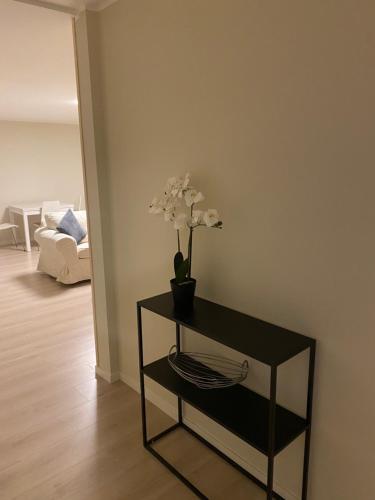 une table noire avec un vase avec des fleurs sur elle dans l'établissement Rom # 3 Appartmenthotel Oslo Adress Isabels vei 16, à Oslo