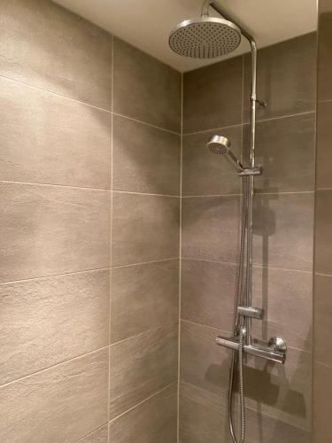 a shower with a shower head in a bathroom at Rom # 3 Appartmenthotel Oslo Adress Isabels vei 16 in Oslo