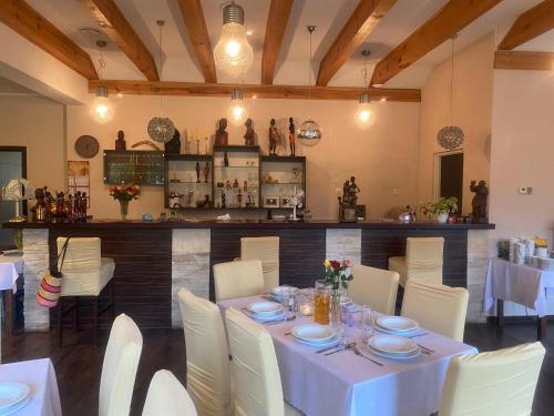 a dining room with a table and white chairs at Hotel Kos in Kosobudz