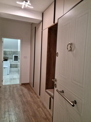 a hallway with a door and a chair in a room at Lilien apartment Airport in Ledine