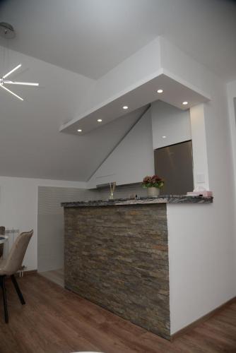 a kitchen with a stone counter top in a room at Lilien apartment Airport in Ledine