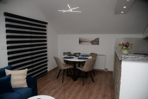 a dining room with a table and chairs at Lilien apartment Airport in Ledine