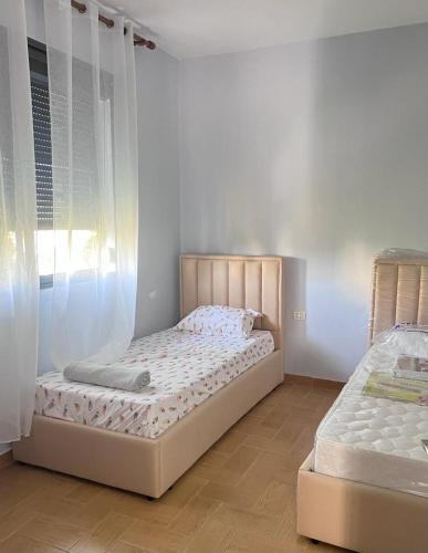 a bedroom with two beds and a window at Vlora Home in Vlorë