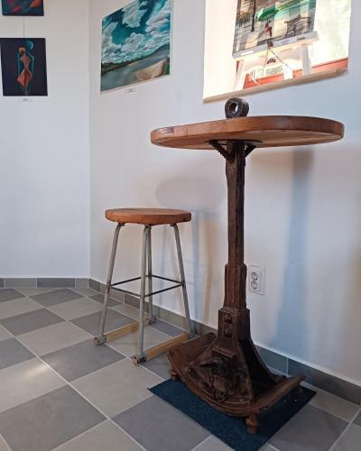 a wooden table and stool on a tiled floor at ToronySzoba in Szob