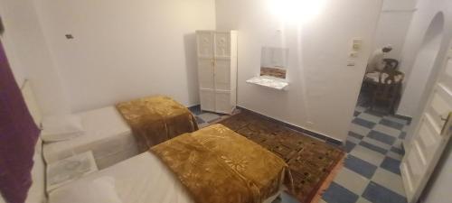 Habitación con 2 camas con cojines de oro. en Sengr Tod, en Asuán