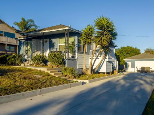 ein Haus mit einer Palme vor einer Straße in der Unterkunft Quaint Mid-Century Cottage by the Coast in Ventura