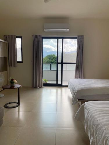 a bedroom with two beds and a large window at Jiu Xingji in Dayin
