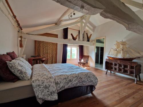 - une chambre avec un lit et un bateau sur le mur dans l'établissement Château Le But proche de Périgueux en Dordogne, à Léguillac-de-Lauche